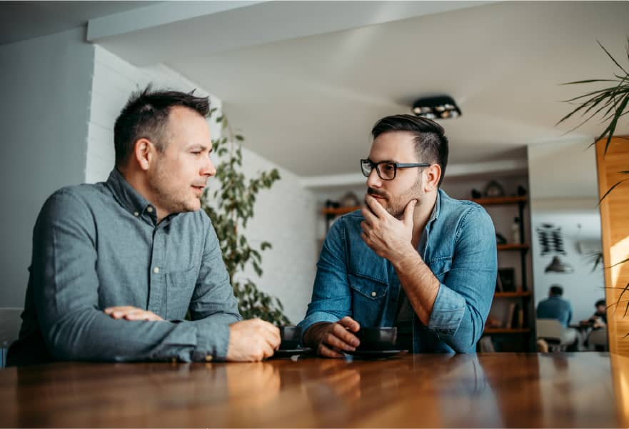 Two co-workers having a focused conversation during a meeting
